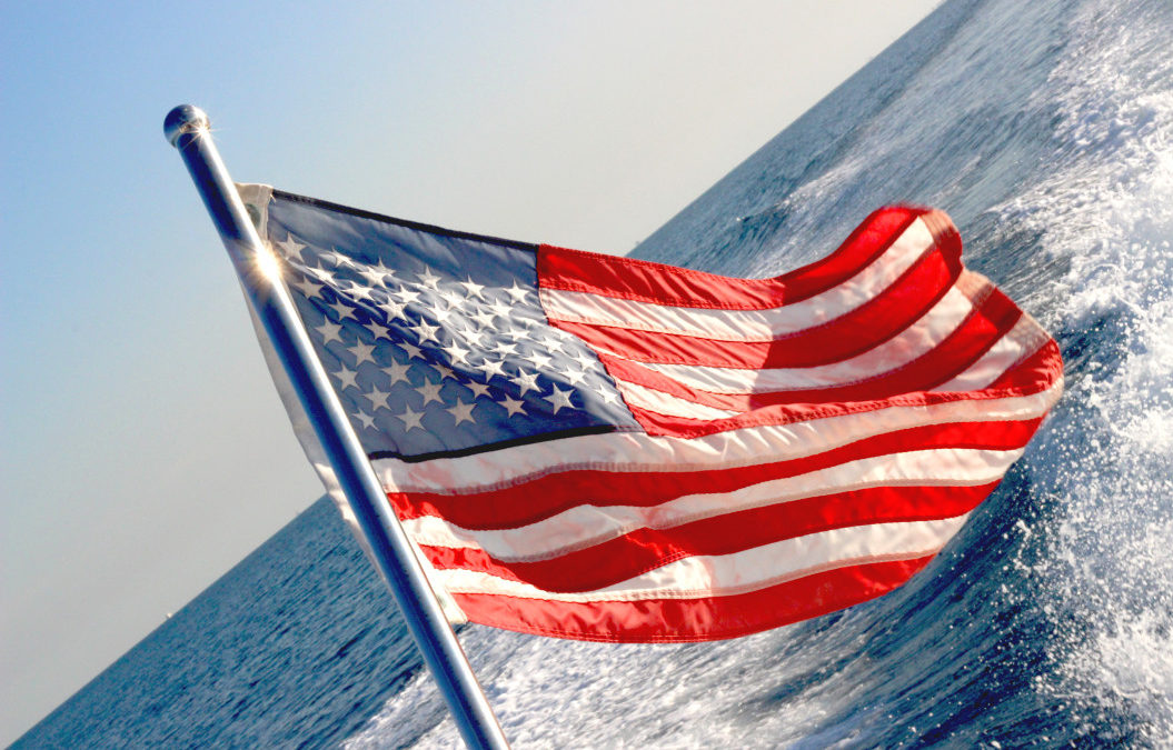 American flag in the wind with a background of water